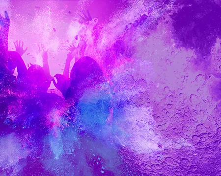 People are seen through a purple-lit haze dancing 