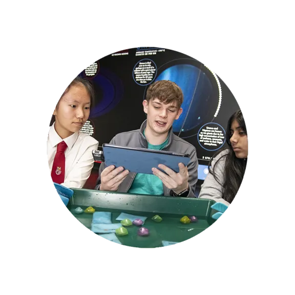 Two pupils and a science communicator conduct an experiment