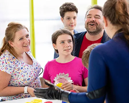 An expert chats with a family in the science centre