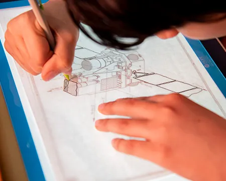 A pupil makes a technical drawing of a satellite