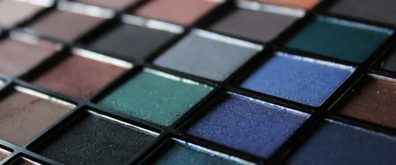 A tray of eye shadow makeup of various colours