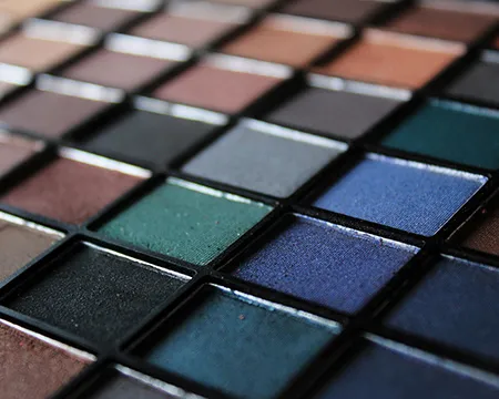A tray of eye shadow makeup of various colours