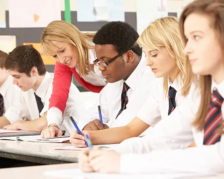 High school students in school uniform work at their desk