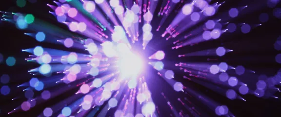 White, purple and blue light hues coming from fibre optic cables
