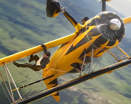 Ethan Hunt hangs from the wing of a plane flying upside down