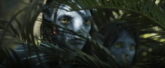 Lo'ak and Tuktirey behind branches.