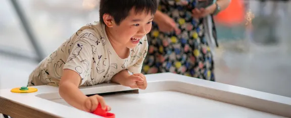 Child plays with the air hockey table