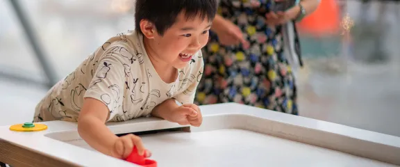 Child plays with the air hockey table