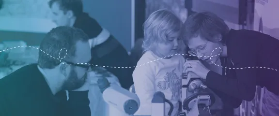 A public engagement practitioner engages a family in an activity