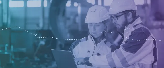 Two engineers looks at digital plans in a work environment