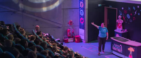 A science show presenter in front of a school audience