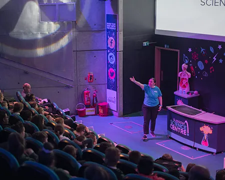 A science show presenter in front of a school audience