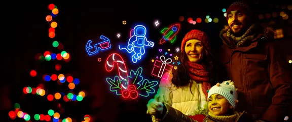 Family excitedly looks at several neon icons representing winter events at Glasgow Science Centre
