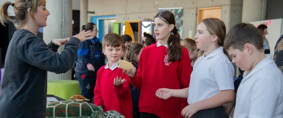 An expert chats with school pupils about objects from the sea