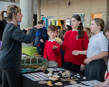 An expert chats with school pupils about objects from the sea