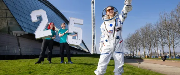 Astronaut Sheena and Science Centre staff post outside the centre with giant 25 numbers