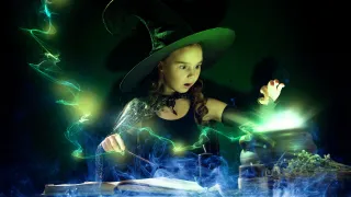 A young girl dress as a witch casts a magical spell