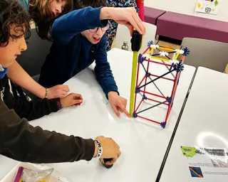 Young people build a tower from K'nex