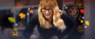 A long-haired blond woman with glasses turns a handle on an exhibit.