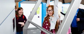 A child tests their grip endurance on our hang time exhibit