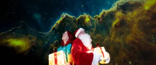 Santa and a Planetarium presenter look into a colourful night sky