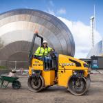 Dr Gillian Lang sits on top of a steam roller as work begins outside Glasgow Science Centre