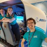 4 members of the flight crew beside a flight simulator in the Newton Flight Academy at Glasgow Science Centre