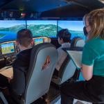 School pupils and flight instructors flying in flight simulator