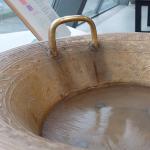 Ripples across water contained in a copper 'singing bowl'.