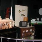 A mini-theatre display in Science in the Dock with dogs, a rocket, a 1960s TV and wallpaper.