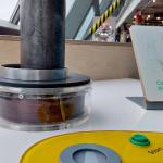 A metal ring sits on a metal pole, atop a magnetic coil. A green start button sits waiting to be pressed.