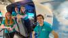 4 members of the flight crew beside a flight simulator in the Newton Flight Academy at Glasgow Science Centre