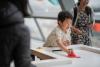 A young visitor plays on the 4-way air hockey table