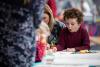 Children colouring in at a table top activity being run by an expert