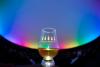 A glass of whisky against the backdrop of the Planetarium. Coloured lighting illuminates the domed ceiling. Text on the glass reads, 'The Good Spirits Company'.