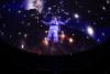 An astronaut against a starry background projected onto the dome of the planetarium