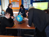 participants deep in discussion looking at a globe