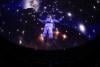 An astronaut against a starry background projected onto the dome of the planetarium