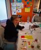 A workshop participant at a table working on their stained glass panels.