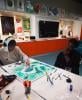 Two people at a workshop table working on their stained glass panels.