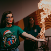 Person wearing a Christmas t-shirt has her hand set on fire in an experiment