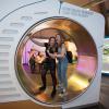 Science Lates - Two guests stand on a giant Hamster Wheel