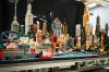 LEGO Gotham city model with skyscrapers, waterfront, an amusement area sign and a small red boat.